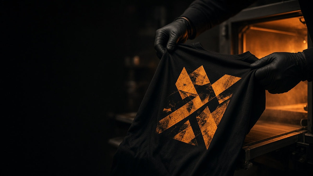 Gloved hands checking a freshly printed shirt at the end of the print line in the Superluxe Merch Phoenix shop