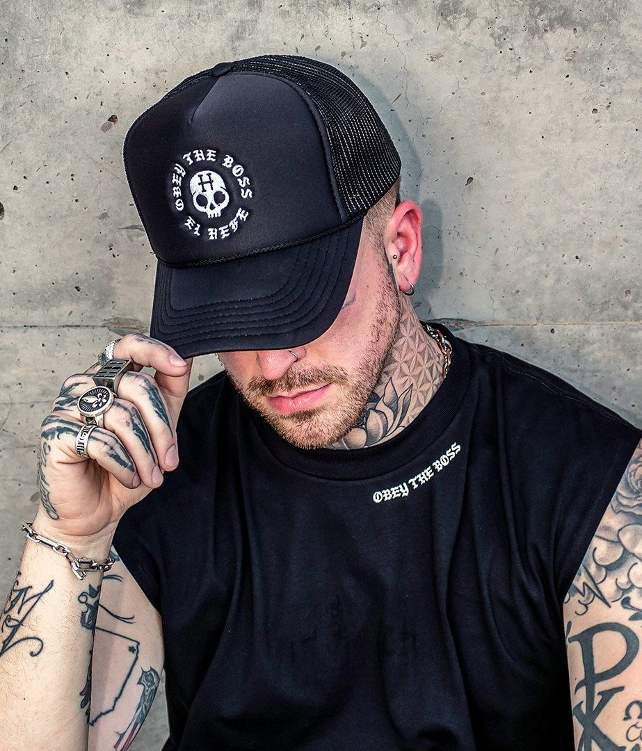 Model in a custom trucker hat and streetwear tee with a printed neck label by Superluxe Merch