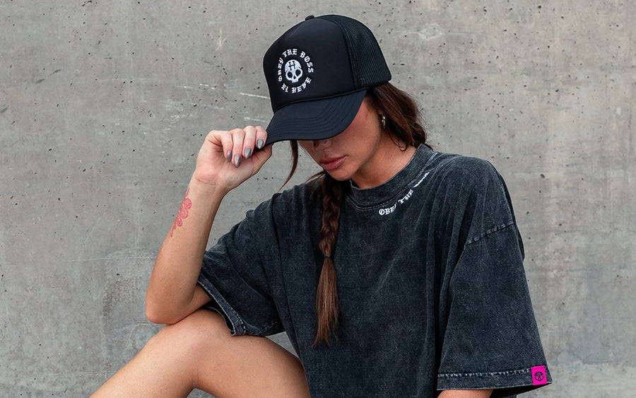 Model in a custom trucker hat and acid-wash streetwear tee made by Superluxe Merch