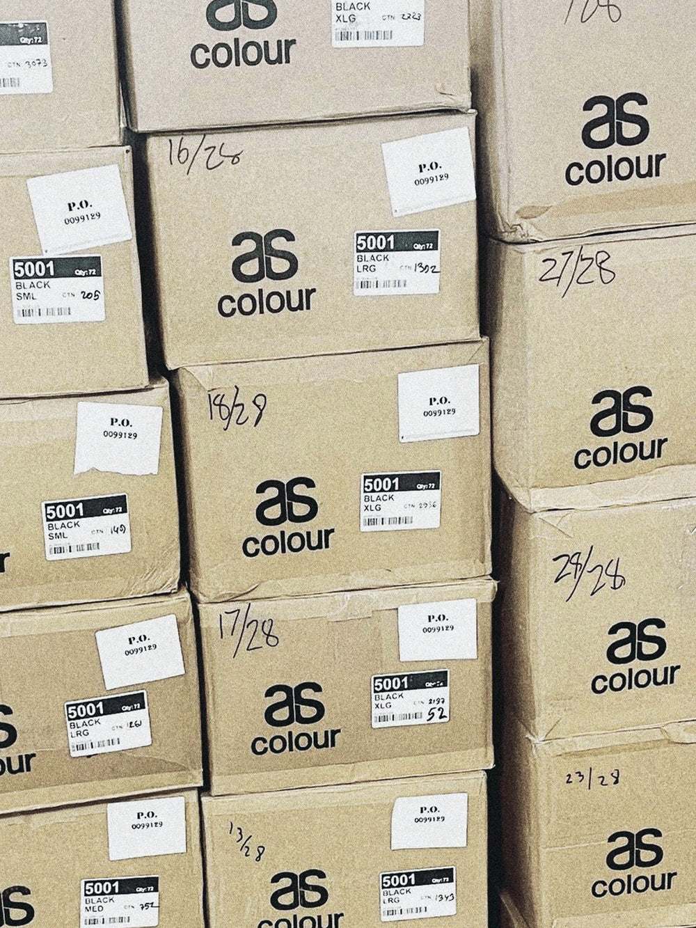 Tall stack of cardboard boxes of blank apparel