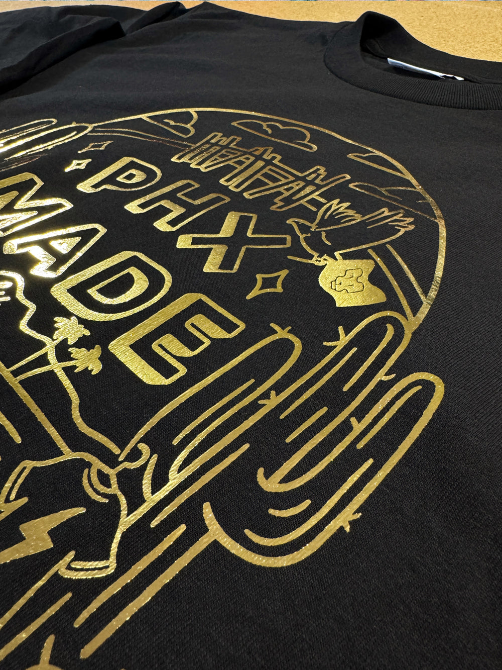 Gold foil print detail on a black tee