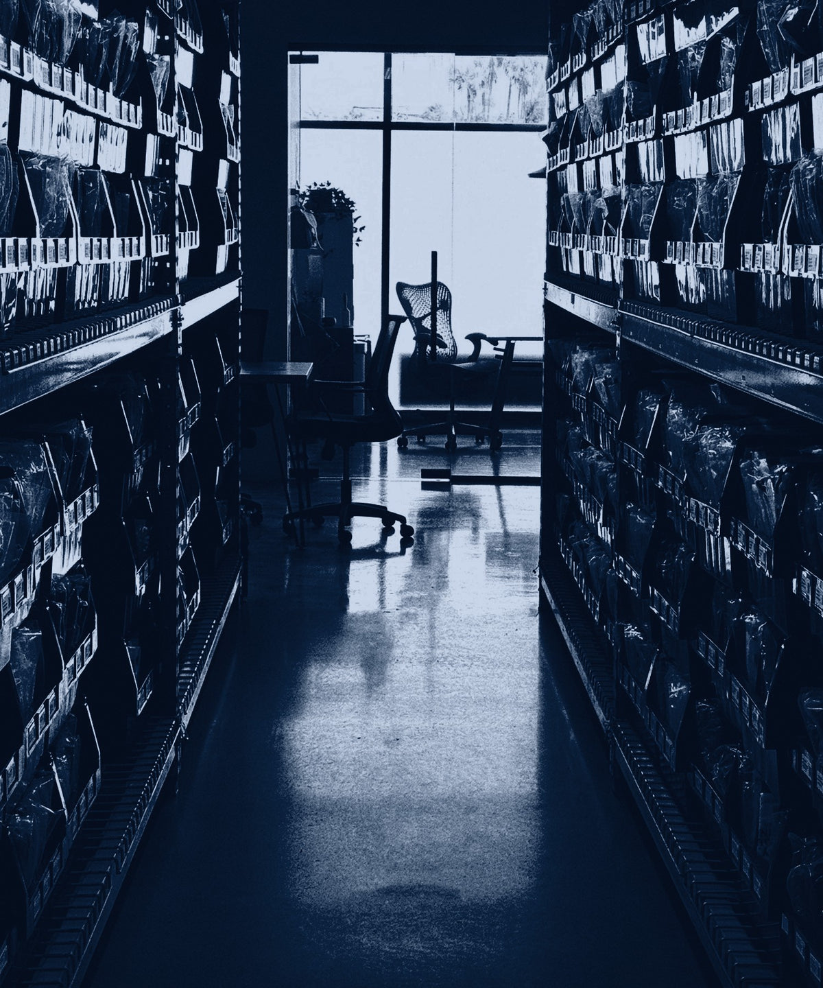 An aisle of shelving with bagged apparel, shown in a navy duotone.