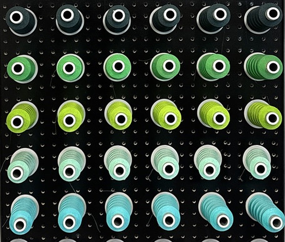 Wall of embroidery thread spools for Superluxe Merch custom embroidery