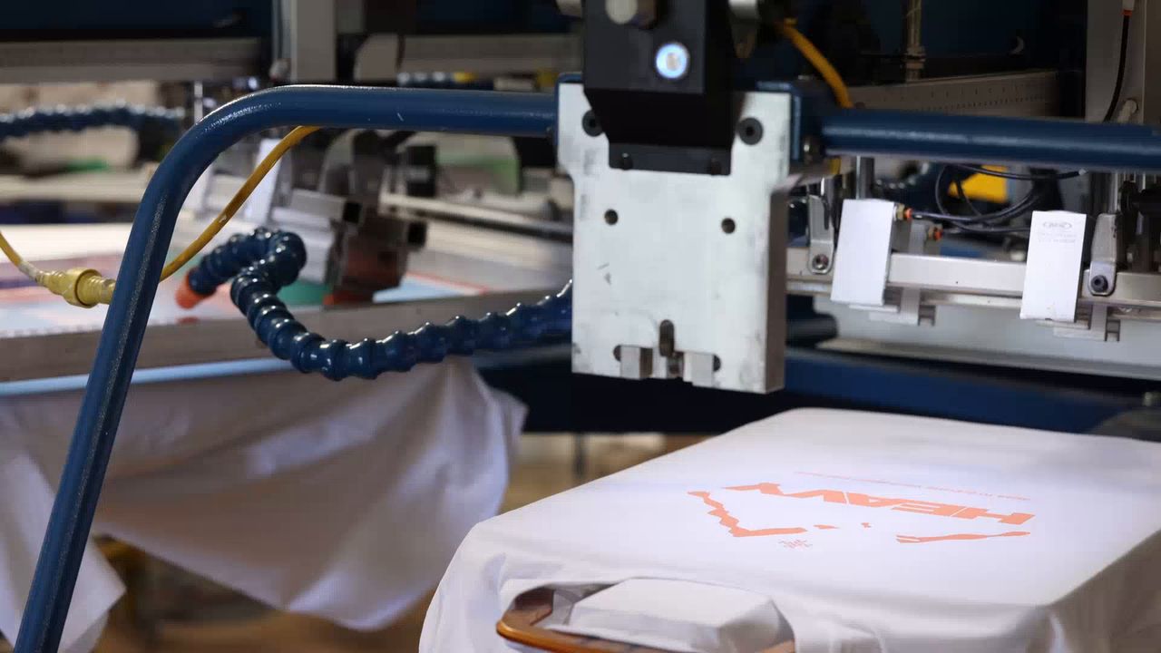 Automatic screen printing press running in the Superluxe Merch shop in Phoenix, AZ